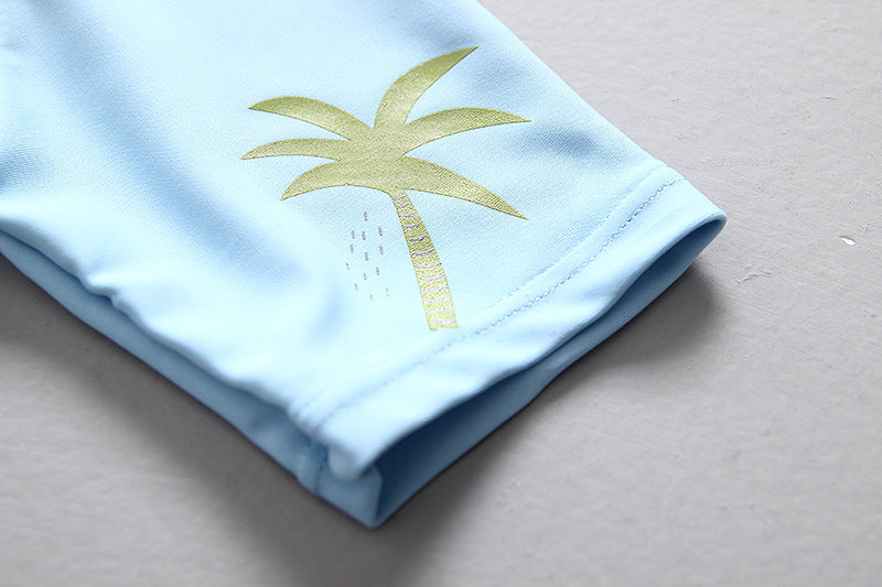 Detail of a boys dinosaur swimming suit featuring a palm tree design, perfect for summer pool days.
